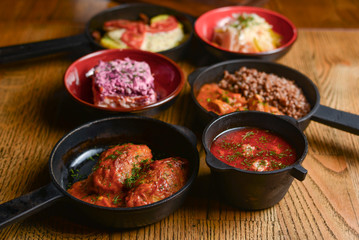 Table with traditional Ukrainian food, boiled buckwheat with meat gravy, meat and mushroom gratin, lazy cabbage rolls.