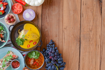 Paprika stuffed pepper with the minced meat and pumpkin sauce served in a pan over rustic wooden table.
