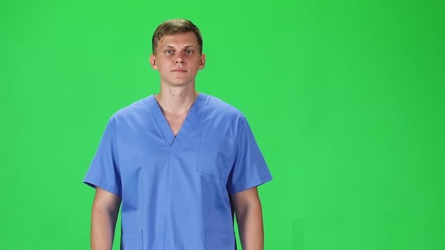 Medical man going and looking forward against a green background. Slow motion.