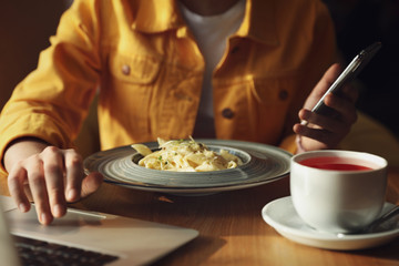 Young blogger working with laptop in cafe, closeup