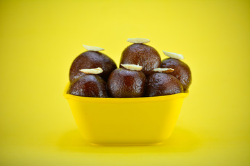 Obraz premium Indian dessert gulab jamun served in yellow bowl