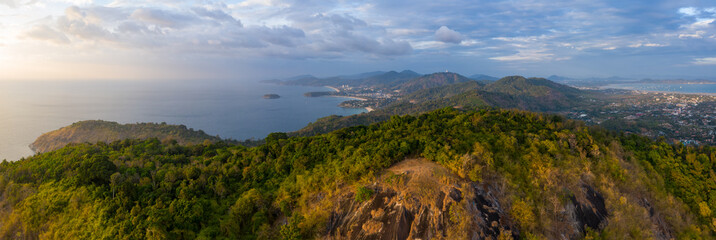 Aerial panorama of the island of Phuket during sunset. Area of the Black Rock viewpoint (the viewpoint itself is an area with dry yellow grass on the foreground). Thailand