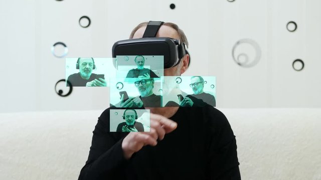 Modern middle-aged man with grey beard choose hologram photo avatar for social network, use VR headset, controls with hands, HUD effect