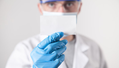 Doctor showing blank business card.