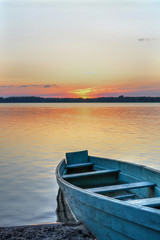 Closeup of an old fishing boat at the lake at sunset.