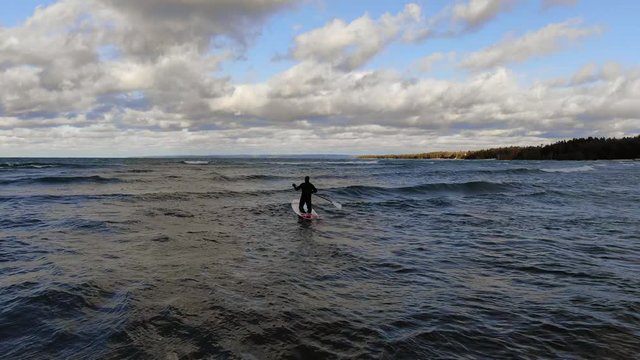Winter stand up paddle surfing in Northern Michigan Charlevoix Petoskey Area on Lake Michigan paddle out dude