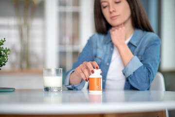 Woman holding a container with life extansion pills