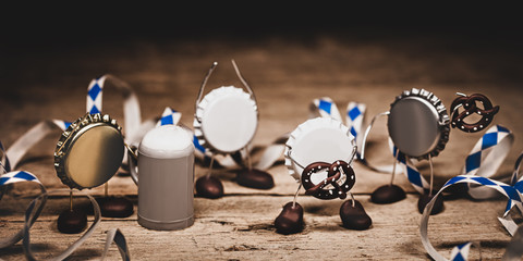 Crown cork miniature figures with paper streamer, beer mugs and bavarian pretzel, concept german festival and oktoberfest