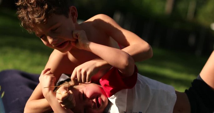 Siblings fighting each other outdoors, real life quarrel authentic