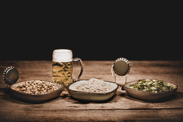 Crown cork miniature figures with barley, hop cones and yeast, concept ingredients for a brewery