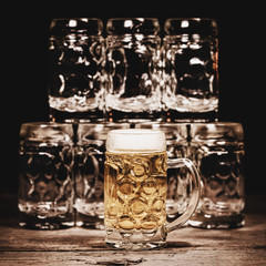 Beer glasses or jugs on wooden table, promotion for gastronomy, pub and tavern
