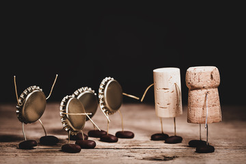 Crown cork, wine and champagne cork miniature figures with a handshake, concept friendship and altruism