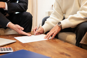 保険契約書にサインをするご主人