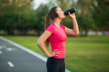 beautiful young woman in sportswear in a summer park