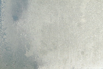 Blue window glass covered hoarfrost ice pattern texture. Cold nature winter background