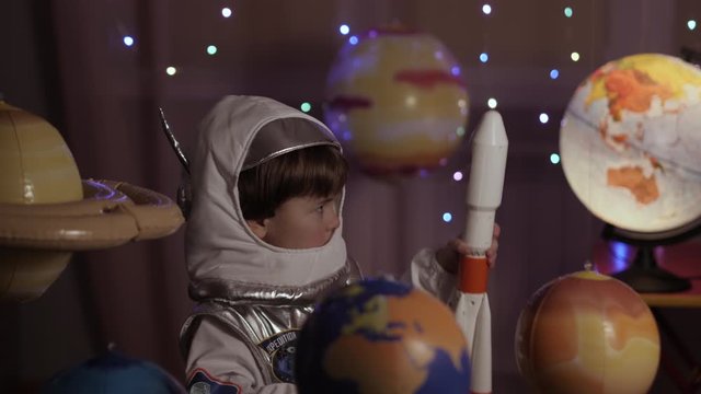Space Travel Game Inspiration Spaceship. Little Kid Boy Astronaut Launching Toy Rocket From Spaceport Through Planets. Child Dreamer Playing With Toy Space Rocket Flying Among Planets. SLOW MOTION.