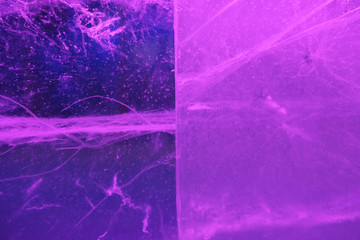 Abstract background of illuminated glossy transparent colored ice texture divided into two parts