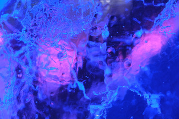 Abstract background of illuminated glossy transparent colored ice texture