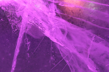Abstract background of illuminated purple ice texture with air bubbles inside, cracks and backlights