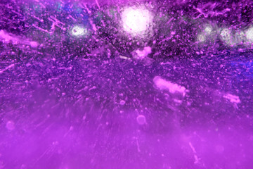 Abstract background of illuminated purple ice texture with air bubbles inside and backlights
