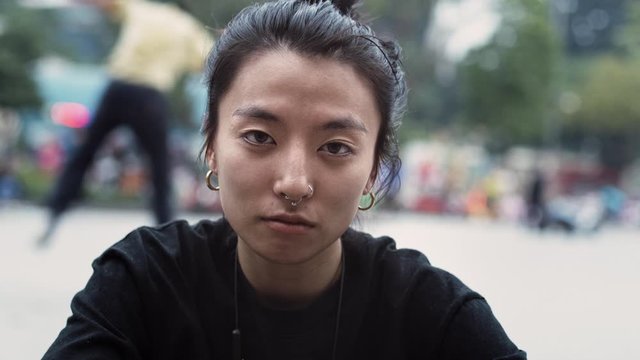 Handheld view of Vietnamese hipster woman looking at camera. Shot with RED helium camera in 8K