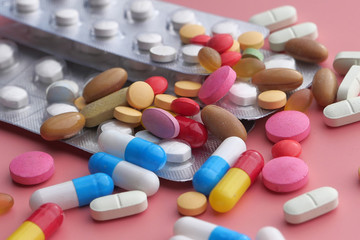 colorful pills and capsule on color background, close up 
