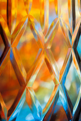 Abstract background of a bright colors through a diamond pattern lead crystal glass vase 