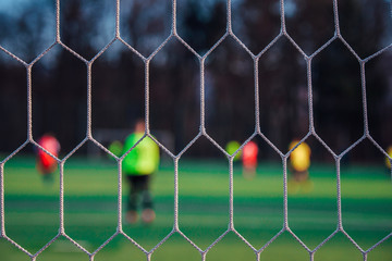 Goalkeeper in football post. Soccer net, blurred background