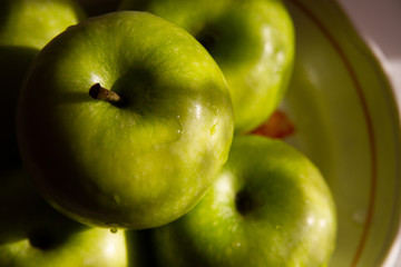 Green apples in a vase close-up blurry plan.