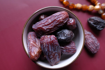 Close up of date fruit in a bowl on color background