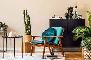 Interior design of retro modern living room with stylish blue navy commode, cacti in lastrico pot, design armchair with pillow, organizer and elegant personal accessories. Stylish home decor. Template