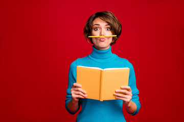 Portrait of funny crazy girl hipster have rest relax during writing report hold copy book pencil nose fooling feel carefree wear blue jumper isolated red bright color background