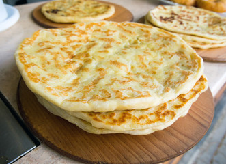 Ready-made Caucasian pancakes lie on a wooden dish