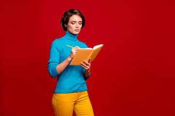 Portrait of focused clever girl write notes in her copybook make report for college courses...