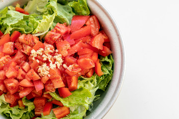 Freshly cut salad with fresh juicy lettuce leaves, red tomatoes and paprika peaces in the metallic bowltomato
