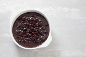 boiled black beans in white bowl on ceramic background