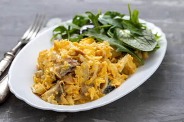 cod fish with mashed eggs on the dish on ceramic background