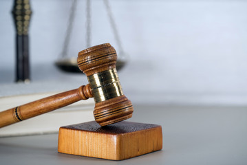 Law theme, mallet of the judge, white wooden background, books