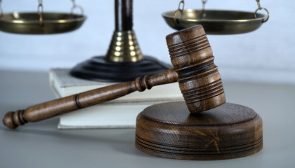 Law theme, mallet of the judge, white wooden background, books