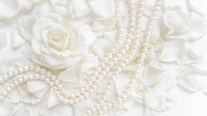 Beautiful white rose and pearl necklace on a background of petals. Ideal for greeting cards for wedding, birthday, Valentine's Day, Mother's Day
