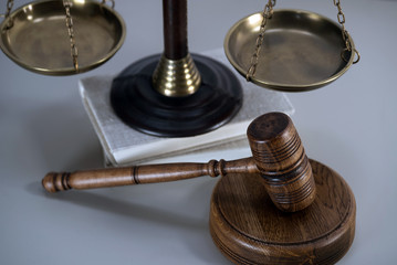 Law theme, mallet of the judge, white wooden background, books