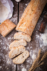 Bread with wheat ears and bowl of flour