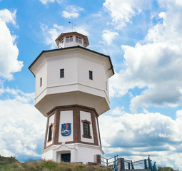 Fototapeta na wymiar A lighthouse and water tower at the island of Langeoog, East Frisian islands, Lower Saxony, Germany