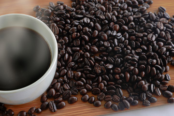 A cup of coffee and beans on the white kitchen table Top view with copyspace for your messages.