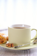 Fresh and rouge rolls with nuts, raisins and meringues on a wooden table and a cup with aromatic coffee