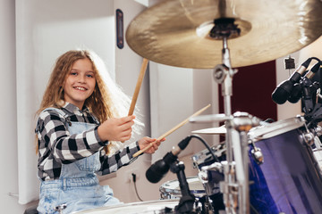 young girl playing drums in music studio