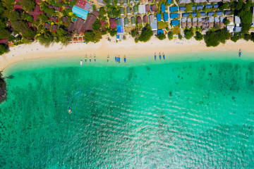 View from above, stunning aerial view of a beautiful tropical beach with white sand and turquoise clear water, long-tail boat and people sunbathing,Long beach, Phi Phi Thailand.