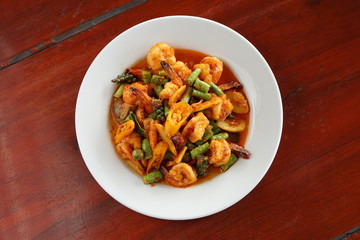 FRIED CHILLI CURRY PAST WITH PRAWNS ON WOOD TABLE WITH COPY SPACE.