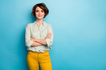 Photo of cool attractive business lady short hairstyle friendly smiling responsible person arms crossed wear casual green shirt yellow pants isolated blue color background