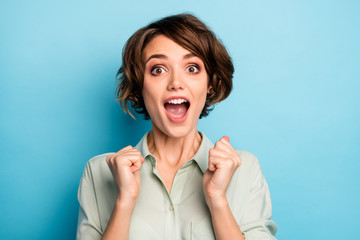 Obraz na płótnie Canvas Closeup photo of funny excited lady raise fists screaming loudly celebrating money lottery winning wealthy rich person wear casual green shirt isolated blue color background
